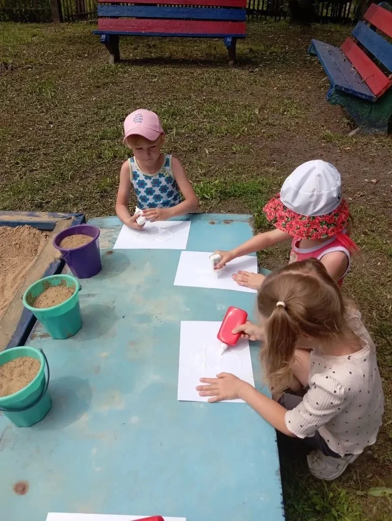 Сегодня на прогулке ребята решили попробовать рисовать песком. Сначала они аккуратно наносили клей н