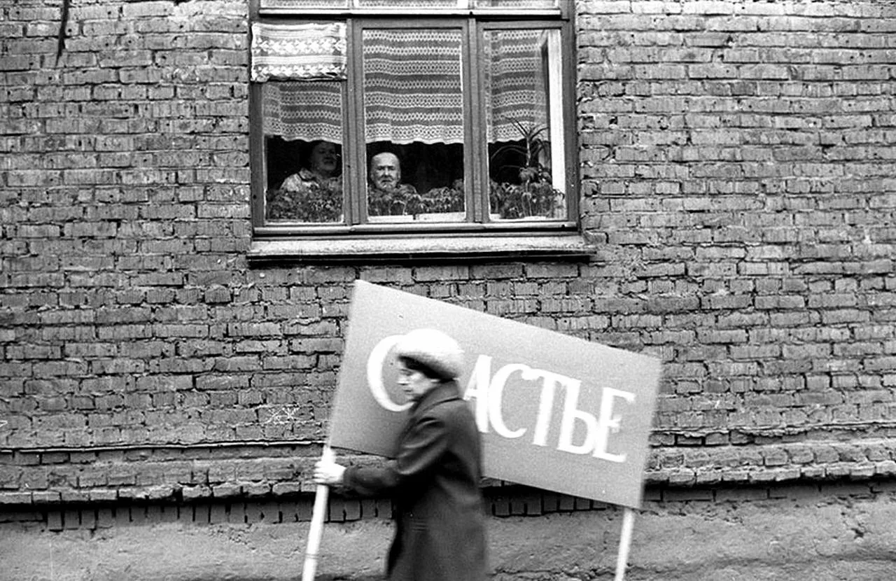 Женщина торопится на Первомайскую демонстрацию, Новокузнецк, 1983 год.