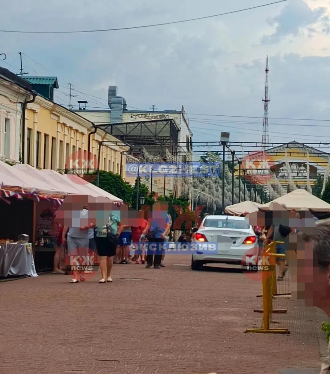 Театральная площадь,  пешеходная аллея, ярмарка, люди , родители с детьми. Включил аварийку и едет. 