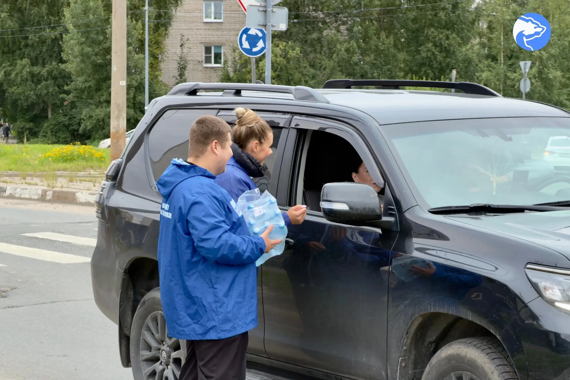 Молодые активисты единороссы раздают воду автолюбителям в топливных очередях Архангельска.