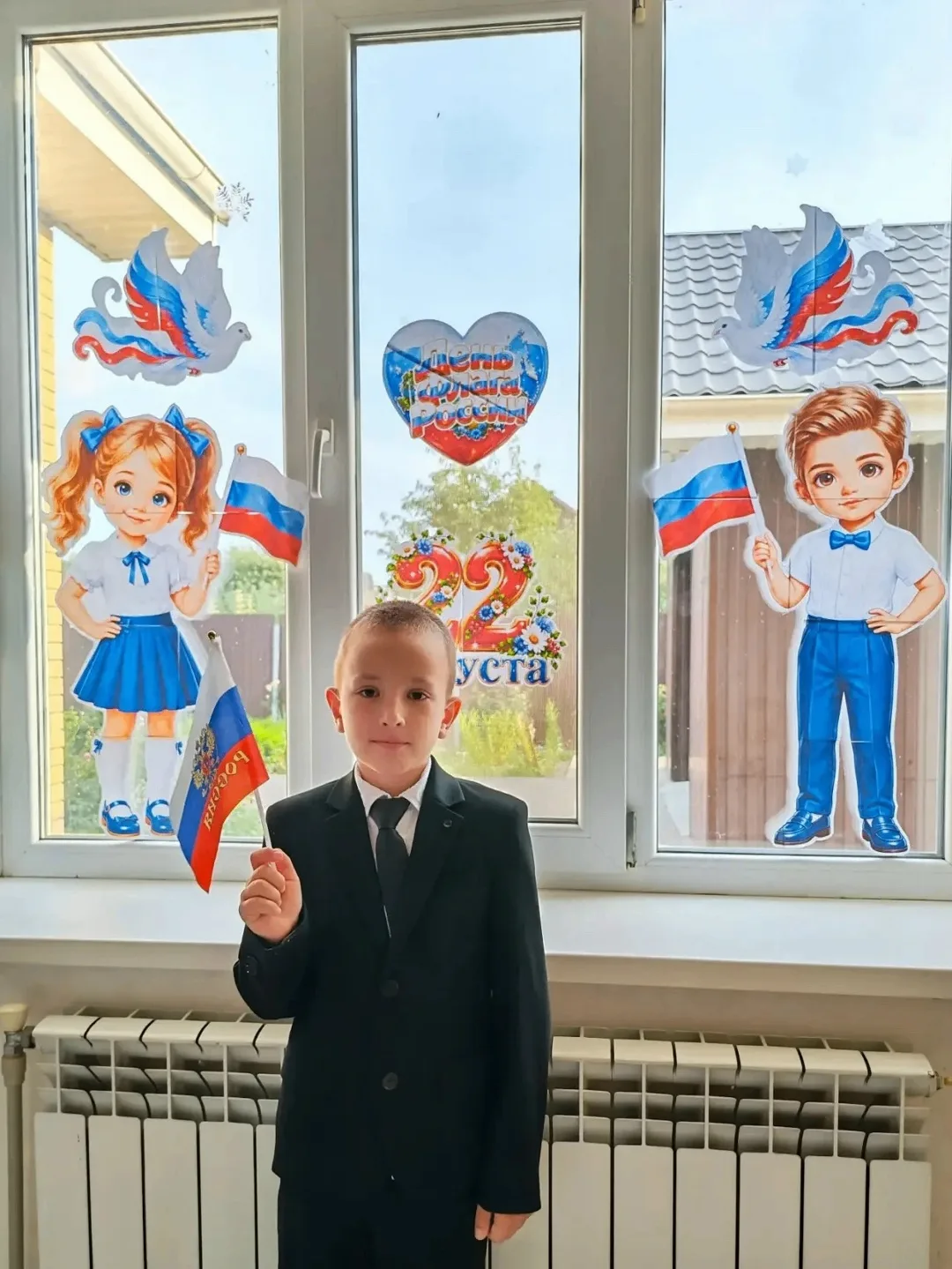 Ученик 3 «Б» класса Злобин Максим принимает участие в акции, посвященной Дню Флага России.