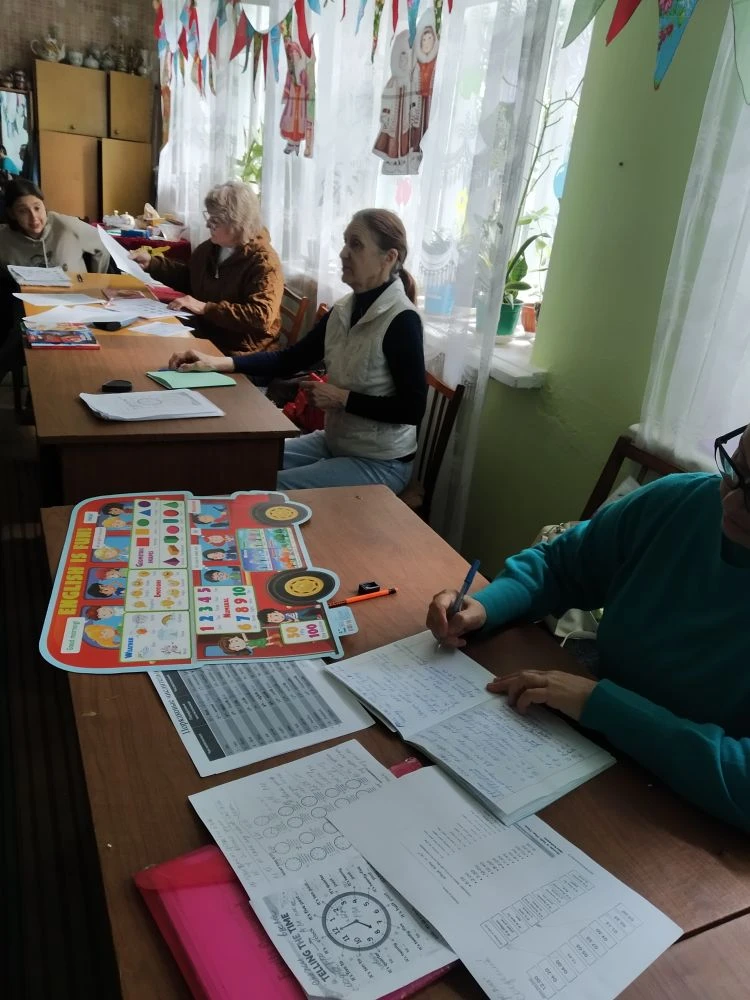 Студенты Университета третьего возраста с увлечением изучают английский язык. Тема занятия "Счет. По