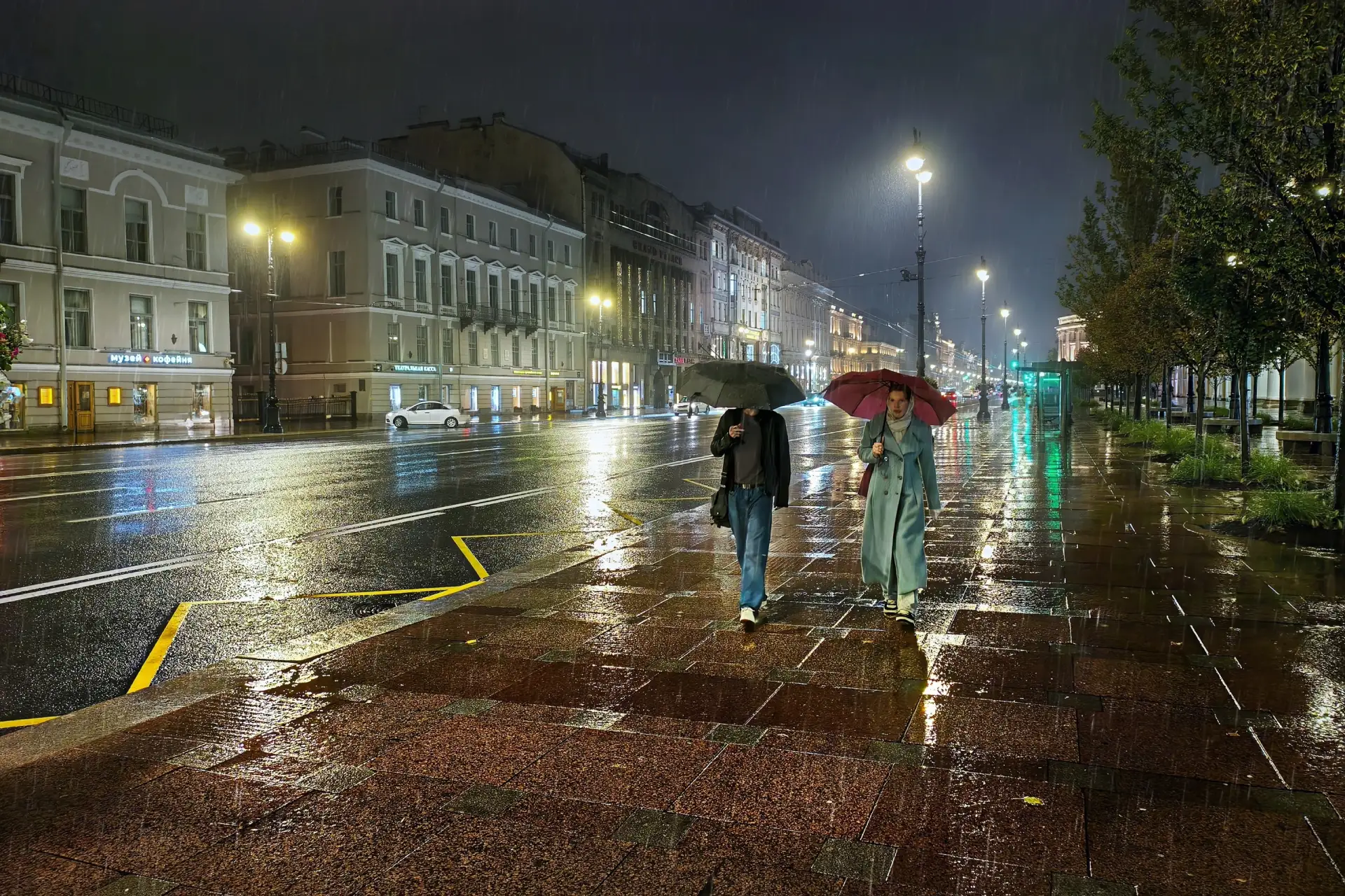 Два человека на улице под проливным дождём.