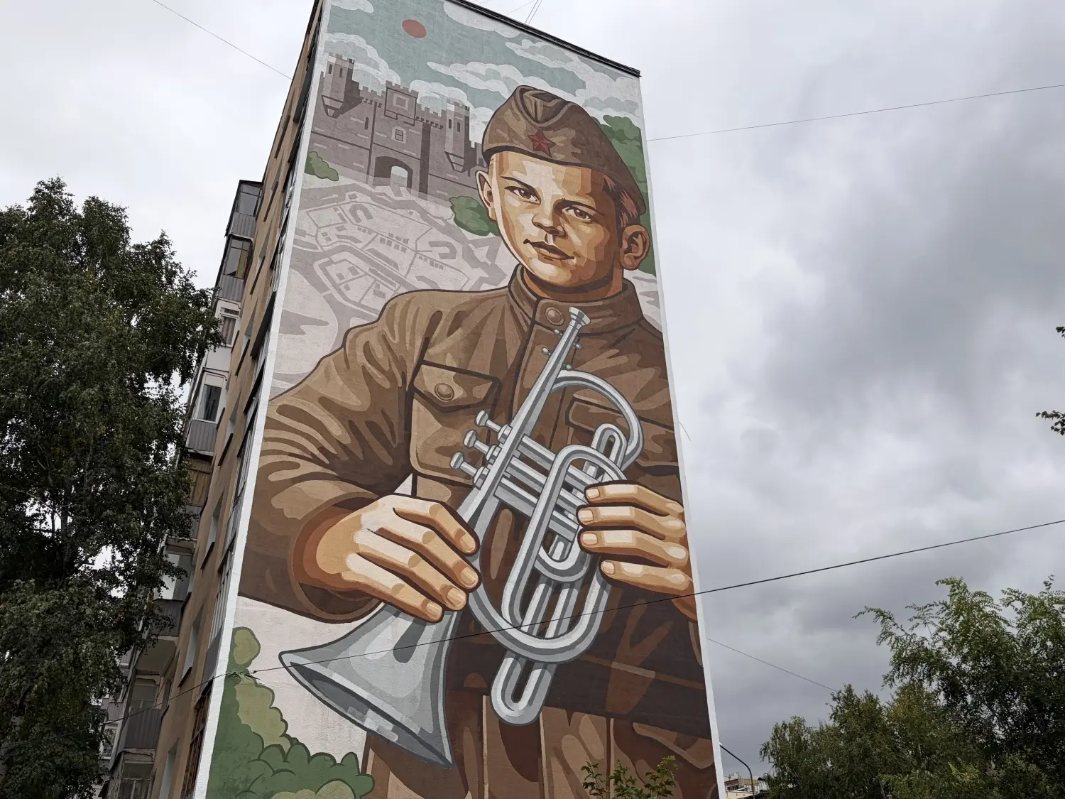Мальчик с музыкальным инструментом на стене дома на улице Карпинского, 22а.