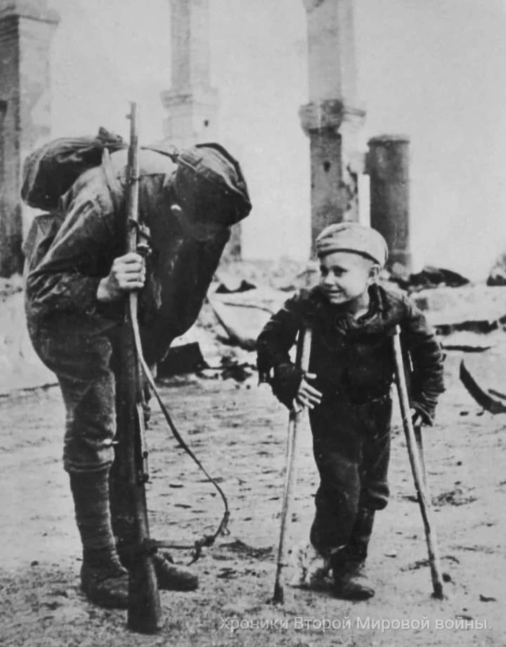 Июль 1944 года, освобождённый Себеж. Боец Красной Армии беседует с десятилетним Володей...