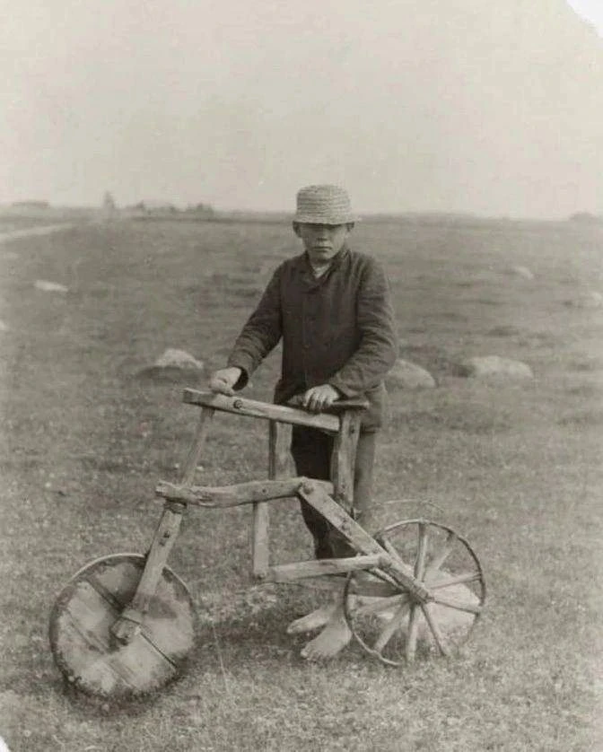 Мальчик из бедной семьи с самодельным деревянным велосипедом, 1912 год.