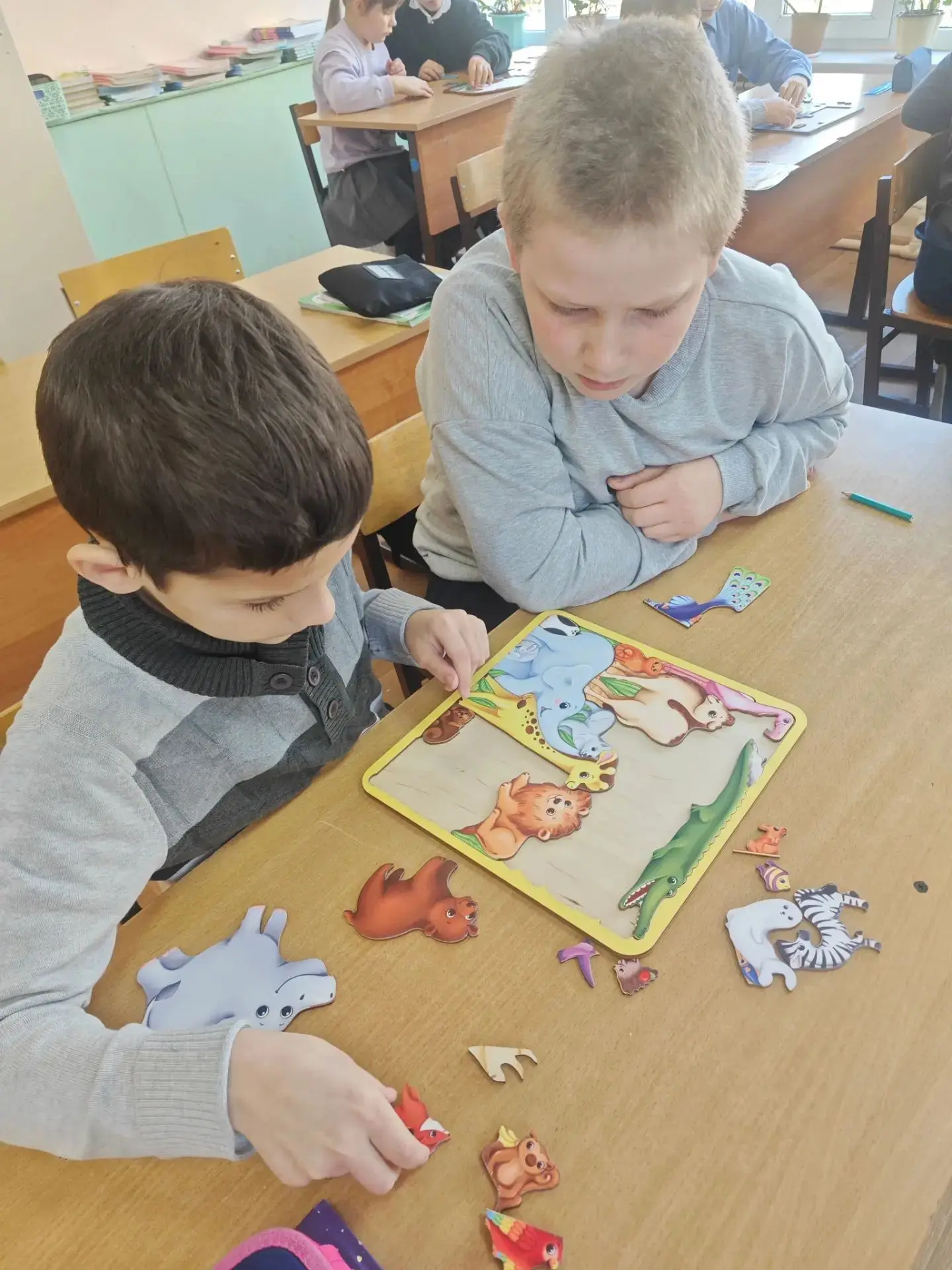Дети на перемене под руководством педагога психолога заняты развивающей игрой: собирают...
