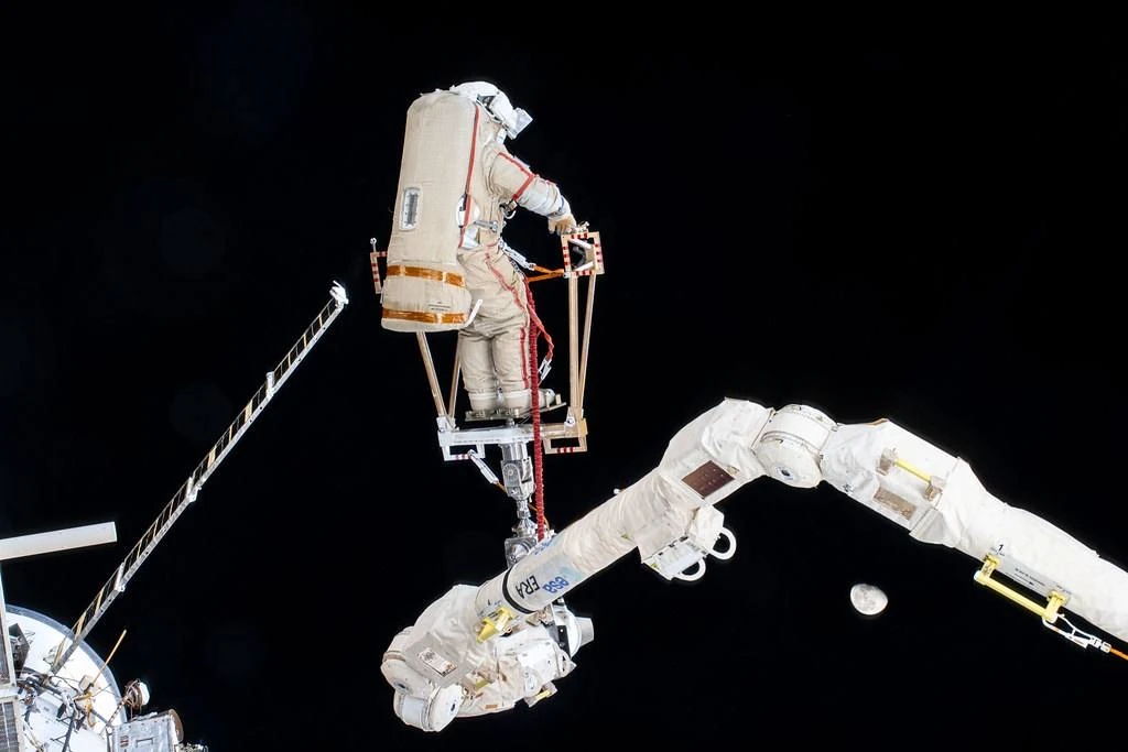 🚀 За бортом МКС — космонавт на роботизированной руке, внутри — его коллега за пультом ...