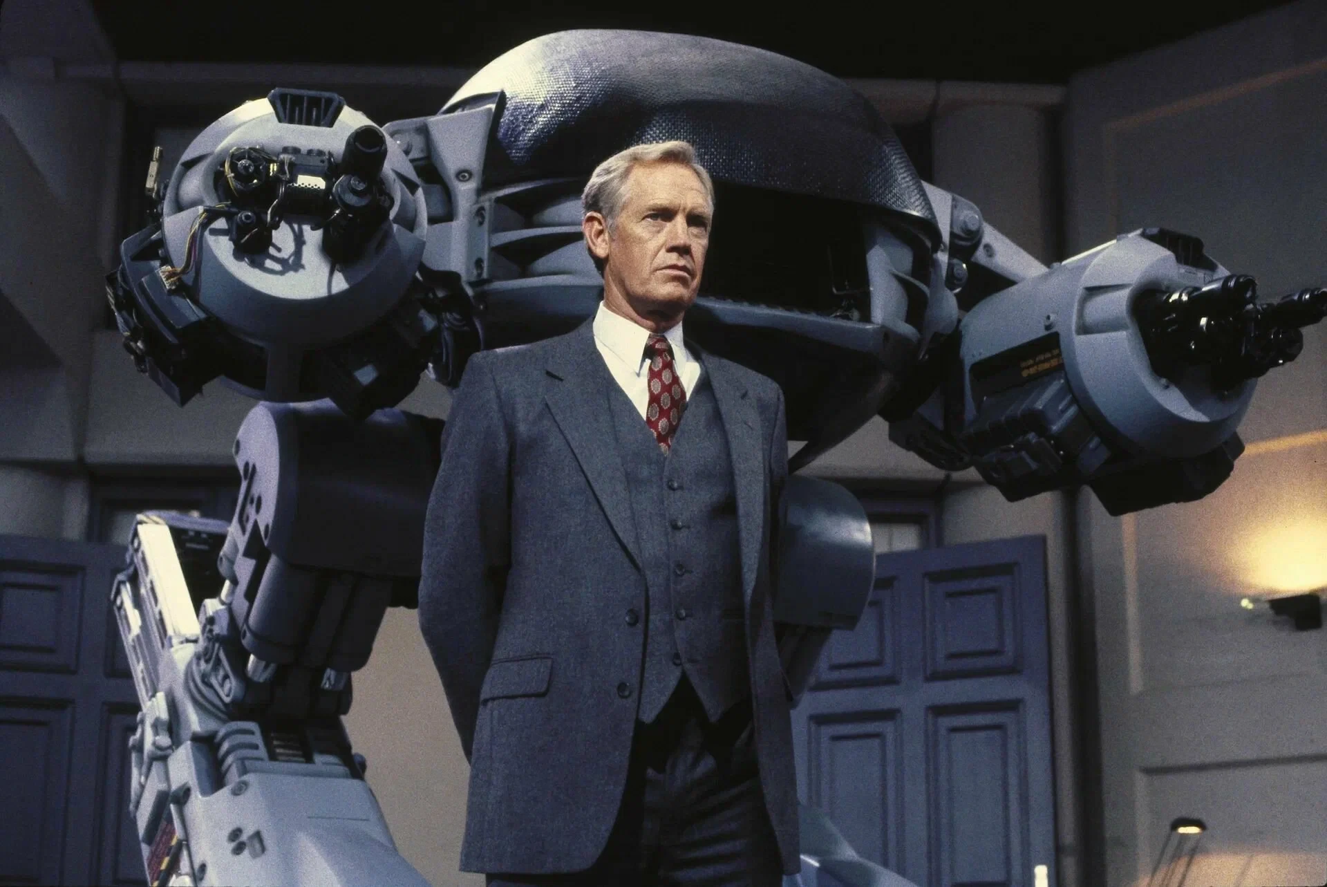 Исполнительный директор OCP Дик Джонс перед роботом ED-209 в фильме «Робокоп» (1987)