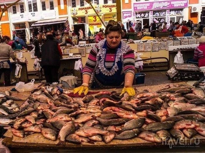 Рыбный ряд. Продавщица торгует угрями. Возле прилавка стоит женщина с невеселым взглядо...