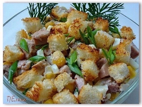 Салат из печени трески с сухариками и кукурузой.