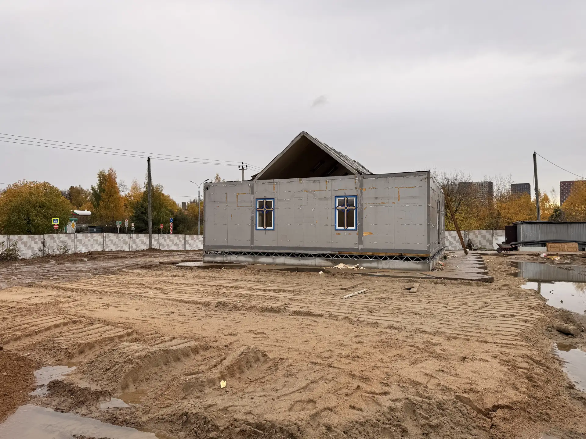 Строительство храма на фоне серопасмурных дней и осенней увядающей природы это в первую...